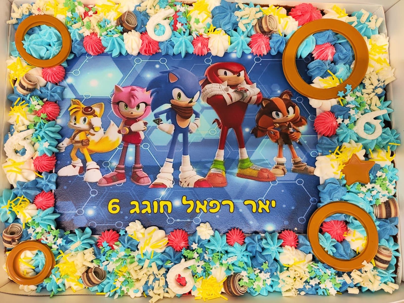 דף סוכר של סוניק וחבריו על רקע כחול, מסגרת קצפת תכולה, טבעות זהב וספרות שש